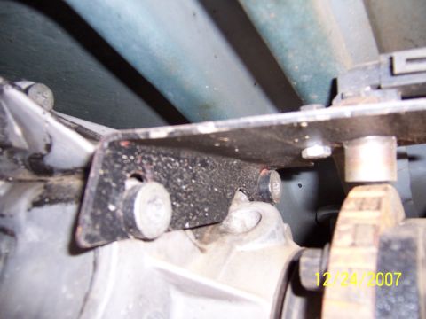 1994 Ford Bronco - Close-up view of vehicle undercarriage components, including a bracket and transmission housing.