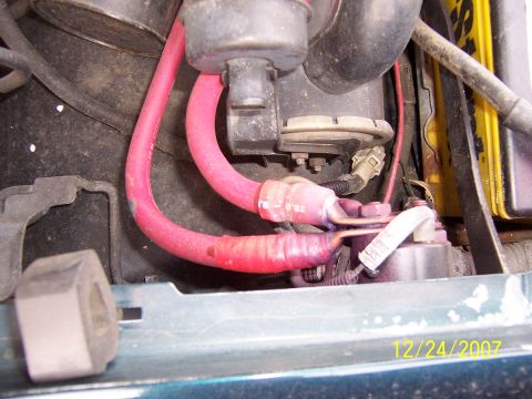 1994 Ford Bronco - Close-up view of the battery terminals and red cables, showing some corrosion.