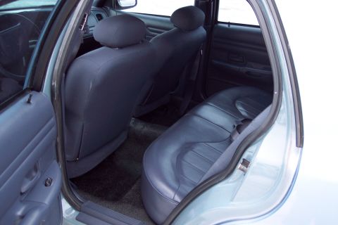 2001 Ford Crown Victoria - The interior of a light blue 2001 Ford Crown Victoria, showing the rear seats and door panel.
