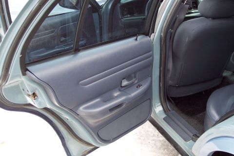 2001 Ford Crown Victoria - Interior view of a 2001 Ford Crown Victoria, focusing on the door panel and rear seating area.