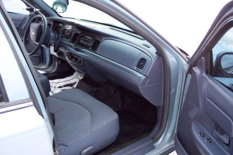 2001 Ford Crown Victoria - Interior view of a police car, showing the dashboard, steering wheel, and front seats.