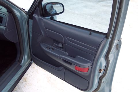 2001 Ford Crown Victoria - Interior view of a 2001 Ford Crown Victoria's driver's side door panel, showing the armrest and window controls.