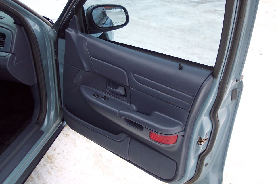 Blue interior door panel of a 2001 Ford Crown Victoria with power window controls and a red reflector