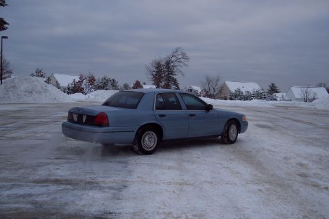 2001 Ford Crown Victoria - A light blue 2001 Ford Crown Victoria is seen from the rear quarter in a snowy environment.