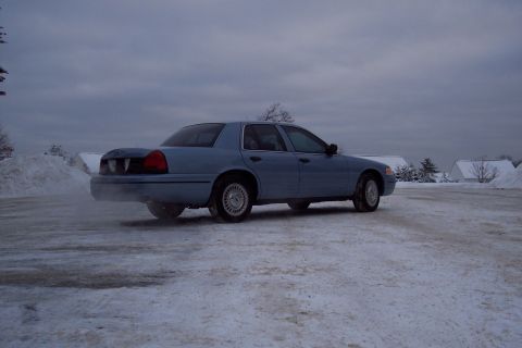 2001 Ford Crown Victoria - Light blue 2001 Ford Crown Victoria parked in a snow-covered lot under a cloudy sky.