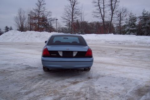 2001 Ford Crown Victoria - A light blue 2001 Ford Crown Victoria is parked in a snowy lot during the day.