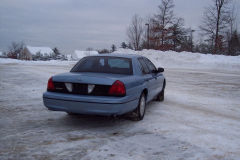 2001 Ford Crown Victoria - Rear view of a blue 2001 Ford Crown Victoria parked in a snow-covered lot.