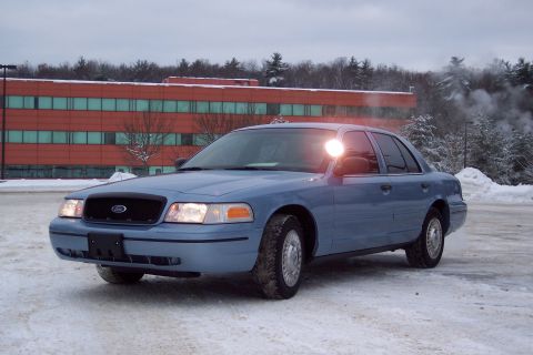 2001 Ford Crown Victoria - This blue 2001 Ford Crown Victoria sedan is seen in a snowy environment with a building in the background.