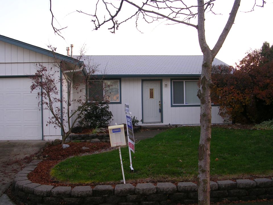 House with garage, front door, windows, and two yard signs in front
