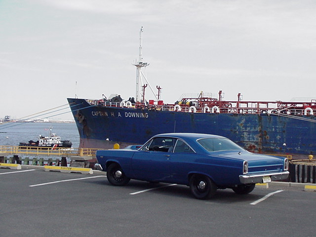 Blue 1966 Ford Fairlane coupe parked on asphalt with white lines, three-quarter front view