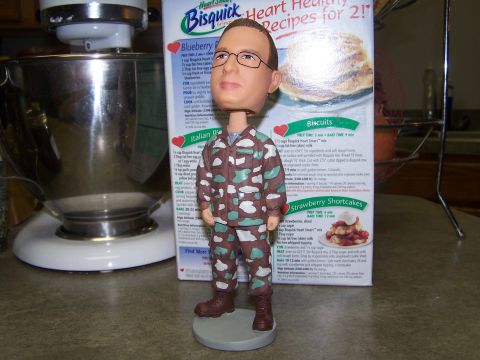 1973 Ford Ranchero - A bobblehead doll dressed in camouflage stands on a countertop next to a box of Bisquick and a kitchen mixer.