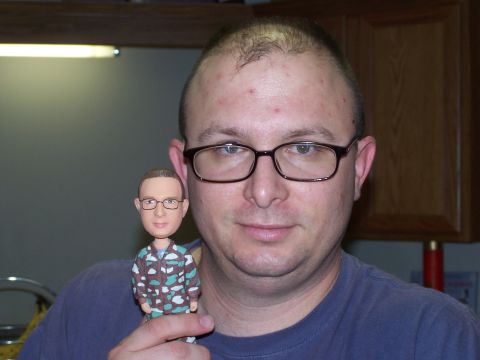 1973 Ford Ranchero - A man holds a custom bobblehead doll that resembles him, complete with glasses and a camouflage shirt.