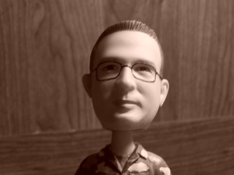 1973 Ford Ranchero - A bobblehead figure wearing glasses and a patterned shirt is shown in a sepia-toned photograph.