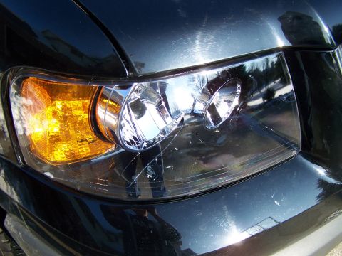 2004 Ford Expedition - Close-up of the front headlight assembly on a black 2004 Ford Expedition.