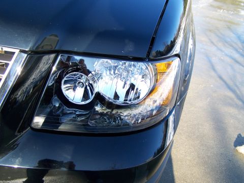 2004 Ford Expedition - Close-up of a black SUV's headlight and part of the grille.