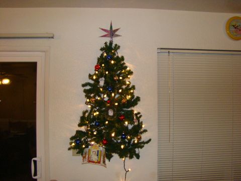 1989 Ford Bronco - A wall-mounted Christmas tree is adorned with lights and ornaments, topped with a star.