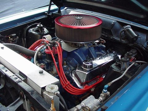 1966 Ford Fairlane - Engine bay of a 1966 Ford Fairlane, a blue engine block, chrome valve covers, and red spark plug wires under a large air filter.