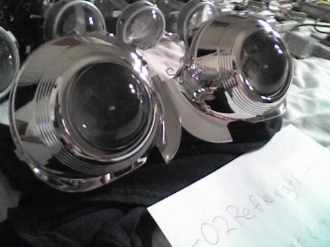 1993 Ford Probe - Two shiny projector headlights are laid out, possibly for installation or repair, with a handwritten note nearby.