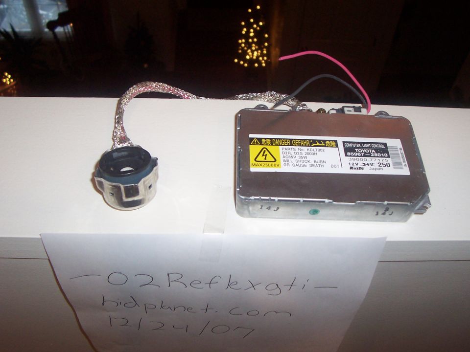 Car headlight ballast and connector with Toyota branding and warning labels