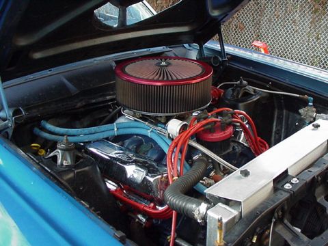 1966 Ford Fairlane - The engine bay of a 1966 Ford Fairlane shows a V8 engine with aftermarket chrome and red accents.