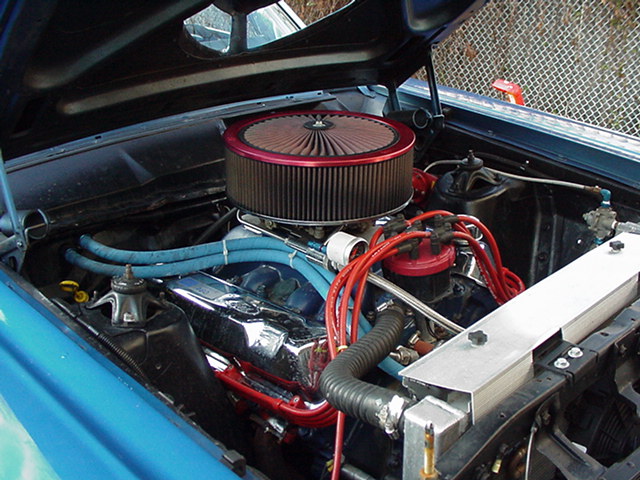 1966 Ford Fairlane engine bay with a large red-trimmed air filter, chrome valve covers, and red spark plug wires