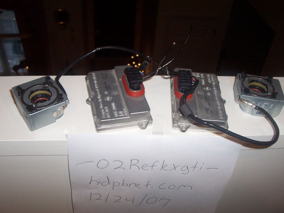 Two HID ballasts and two igniters on a shelf. Paper in front has writing: '-02 Reflexgti- hidplanet.com 12/24/07'
