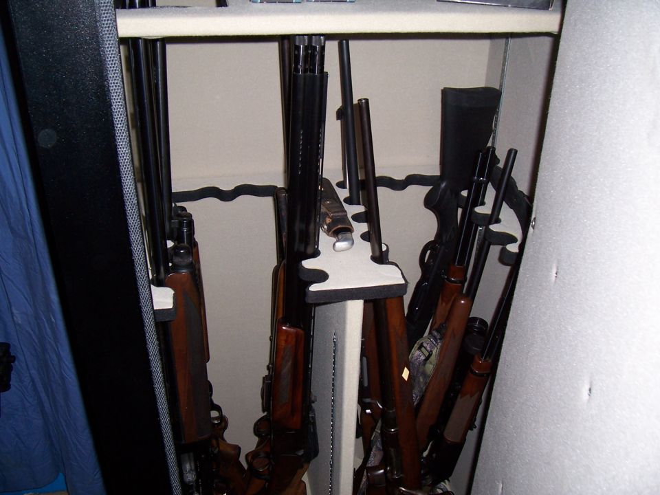 Guns stored vertically in a gun safe with foam holders