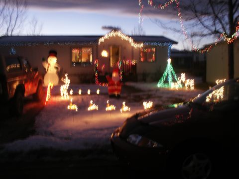 1995 Ford Bronco - A festive scene with two vehicles parked in front of a house adorned with Christmas lights and decorations.