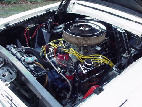 1966 Ford Fairlane - Close-up of a V8 engine compartment with chrome accents and yellow spark plug wires.