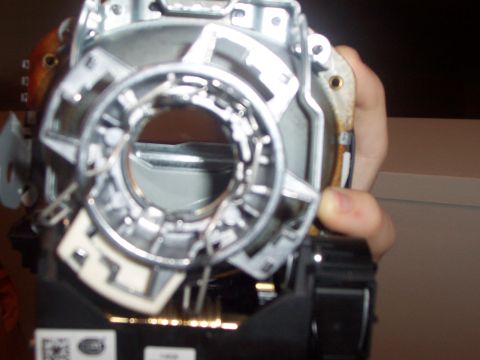 1993 Ford Probe - A person is holding a complex headlight assembly part, likely for a vehicle.