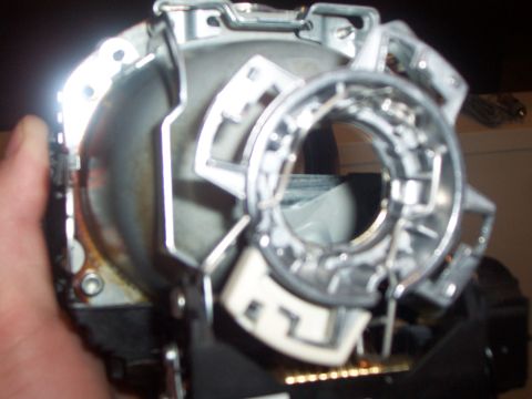 1993 Ford Probe - A person is holding a disassembled car headlight assembly, showing internal components.