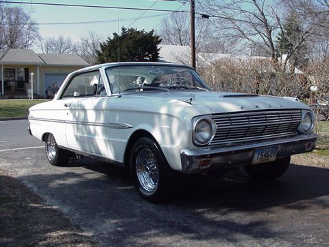 1966 Ford Fairlane - A white 1963 Ford Falcon coupe is parked on a driveway, showing its distinctive grille and front end.