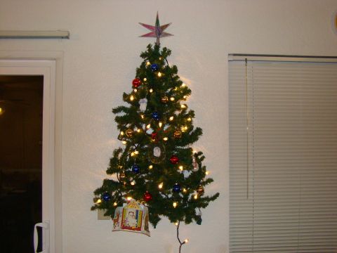 1989 Ford Bronco - A decorated Christmas tree hangs on a wall, adorned with lights and ornaments, ready for the holidays.