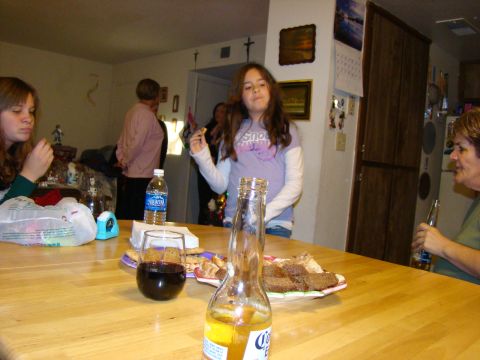 1989 Ford Bronco - A casual gathering with food and drinks on a wooden table, with several people interacting in the background.