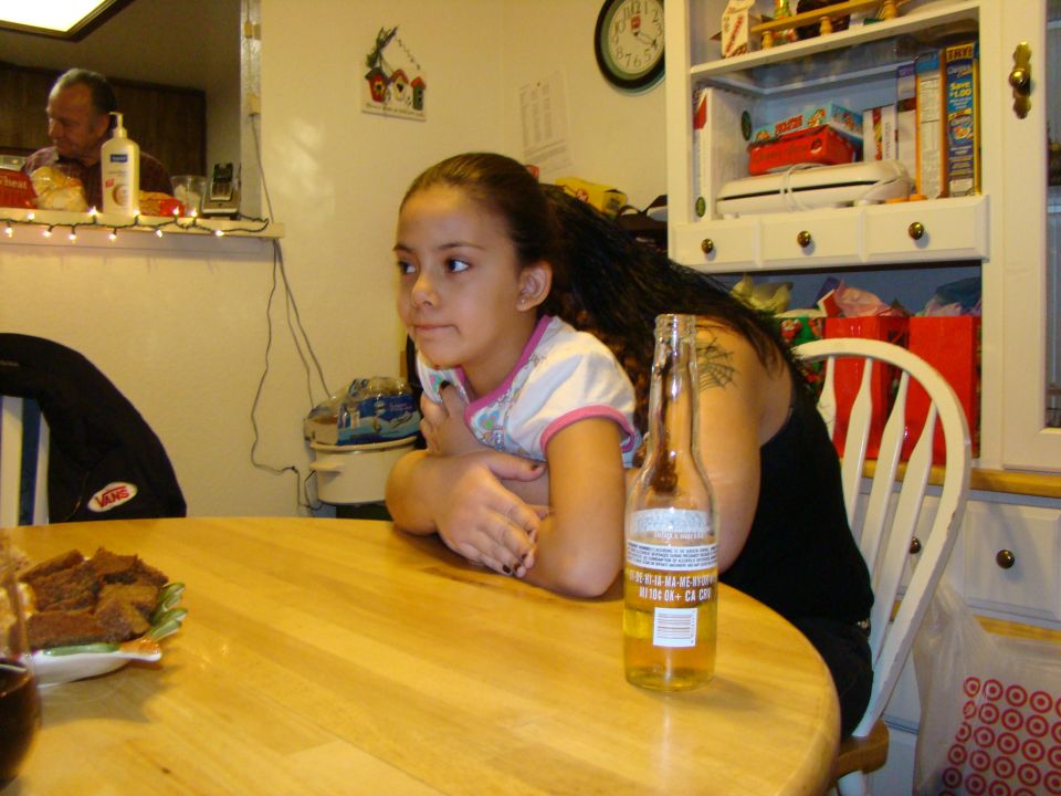 Girl and man at a table with a beer bottle and food