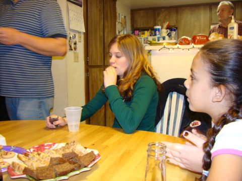 1989 Ford Bronco - A group of people are sitting around a table, with food and drinks present.