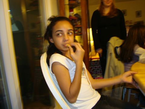 1989 Ford Bronco - A young girl is captured mid-bite while seated at a table, with others visible in the blurred background.