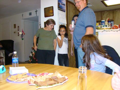 1989 Ford Bronco - A group of people are gathered indoors, with food and drinks on a table, and a Christmas tree in the background.