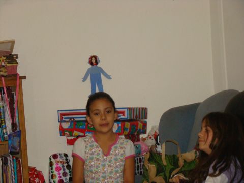 1989 Ford Bronco - A young girl stands in a room with gifts and decorations, while another girl watches from a couch.