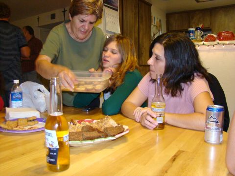 1989 Ford Bronco - A group of people are enjoying food and drinks around a table, with a woman serving cookies.