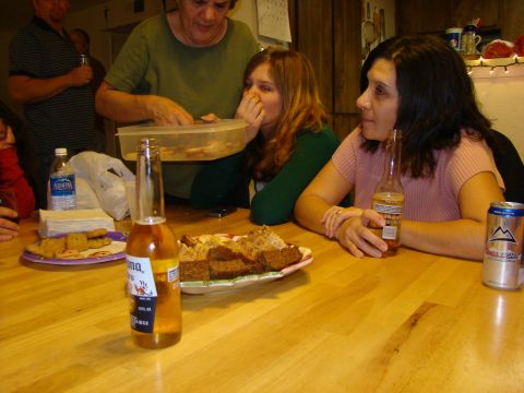 1989 Ford Bronco - A group of people are gathered around a wooden table, sharing food and drinks.