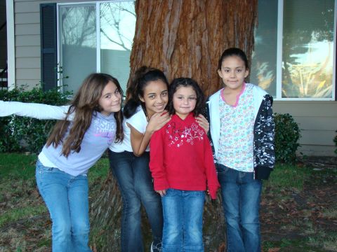 1989 Ford Bronco - Four young girls pose for a photo in front of a large tree and a house.