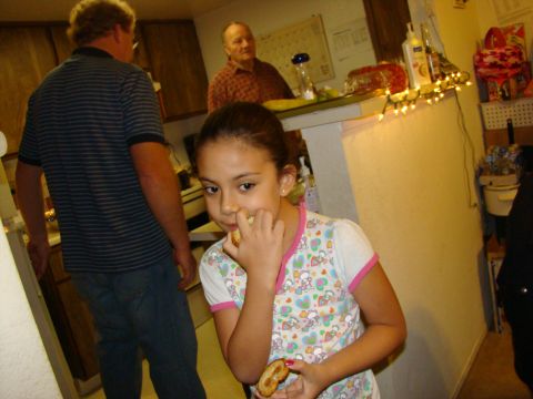 1989 Ford Bronco - A young girl eats a pretzel in a kitchen setting, with two men visible in the background.