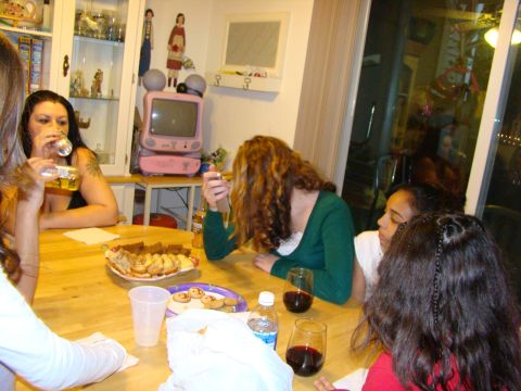 1989 Ford Bronco - A group of people are seated around a wooden table, with food and drinks laid out before them.