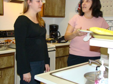1989 Ford Bronco - Two women converse in a kitchen setting with a sink and stove visible.