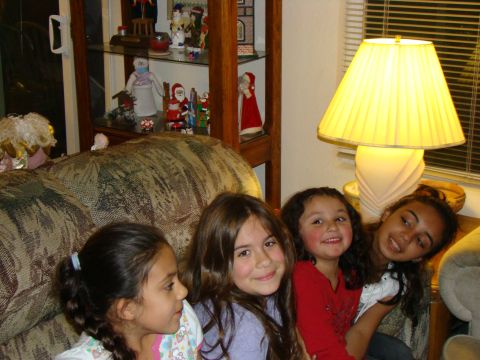 1989 Ford Bronco - A group of four young girls are gathered together on a couch, with holiday decorations visible in the background.