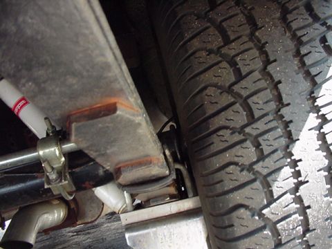 1966 Ford Fairlane - Undercarriage view of a vehicle's suspension system, focusing on the leaf spring and tire.