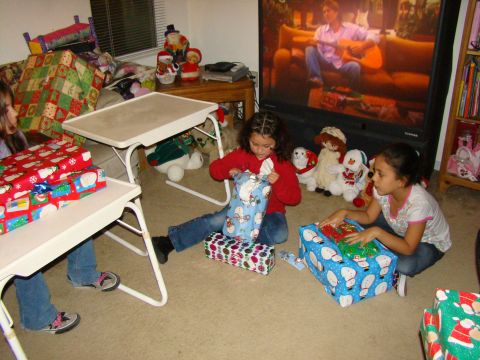 1989 Ford Bronco - Children excitedly open Christmas presents in a living room, with a television playing in the background.