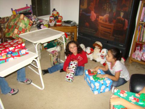 1989 Ford Bronco - Children excitedly open gifts during a holiday celebration, surrounded by wrapped presents and stuffed toys.