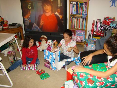1989 Ford Bronco - Three girls unwrap gifts on Christmas morning while a TV plays in the background.